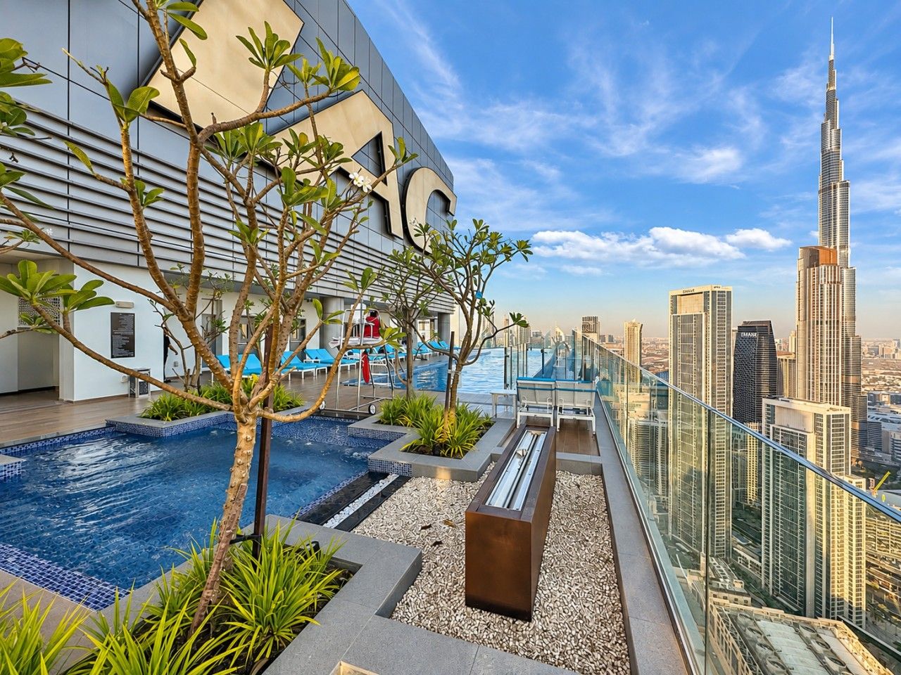 A rooftop pool area with a view of the Burj Khalifa.