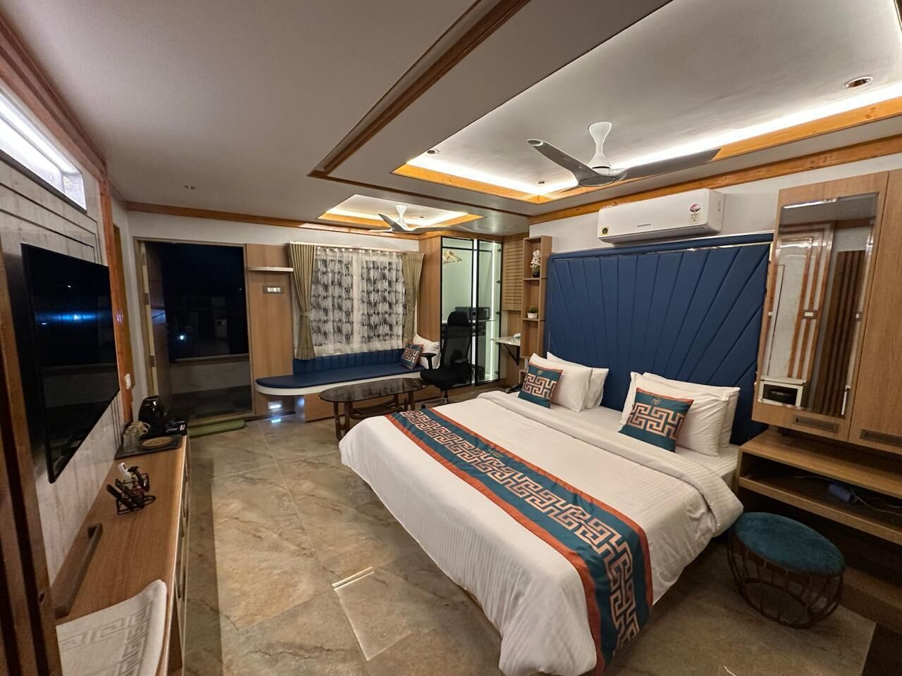 Ein modernes Hotelzimmer mit einem großen Bett, einem Schreibtisch, einem Fernseher und einer Sitzecke.
