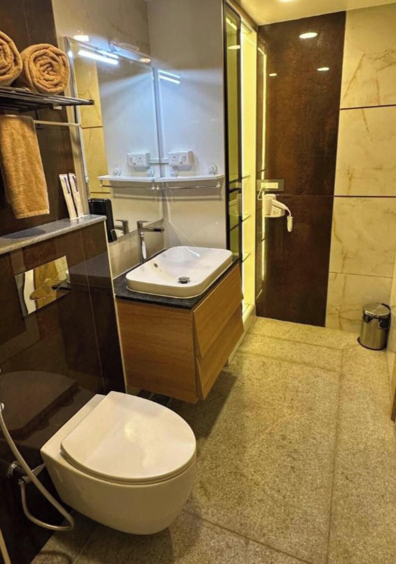 A modern bathroom with a toilet, sink, and glass shower enclosure.