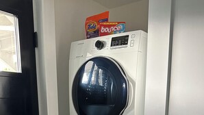 A stacked washer and dryer unit with a Tide Bounce detergent box on top. - Private suite steps away from the ferry and some of Powell River's best dining. (Powell River)