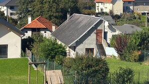 A residential area with houses, a grassy field, and mountains in the background.