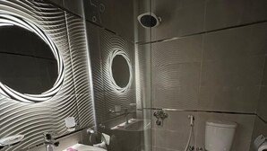 A modern bathroom with a glass-enclosed shower, a sink with a mirror, and a toilet. - Royal Home Hotel (Cairo)