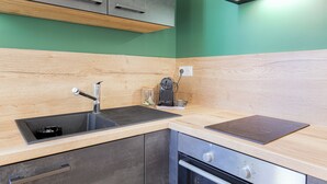 Une cuisine moderne équipée d’un évier, d’une cuisinière et de meubles de rangement en bois.