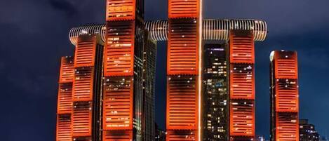A high-rise building with multiple illuminated floors and a distinctive architectural design.