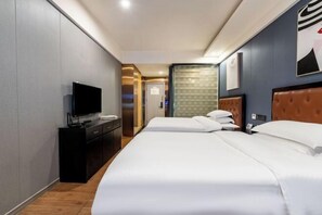 A hotel room with a bed, a TV, a desk, and a door leading to another room. - Tilentin E-sports Hotel (Chongqing)