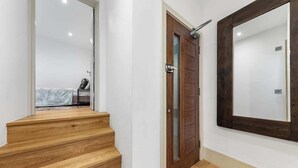 A staircase leading to a bedroom with a bed and a bedside table. - Modern Spacious 1 Bed Flat near Richmond Park and River Thames  (London)