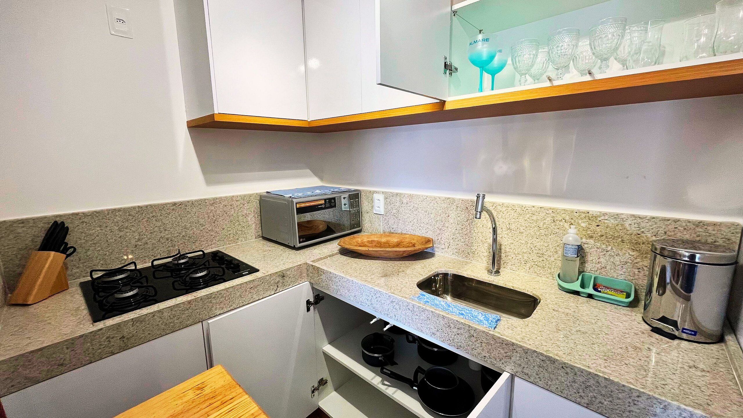 A compact kitchen with a built-in oven, a microwave, a sink, and a small countertop.