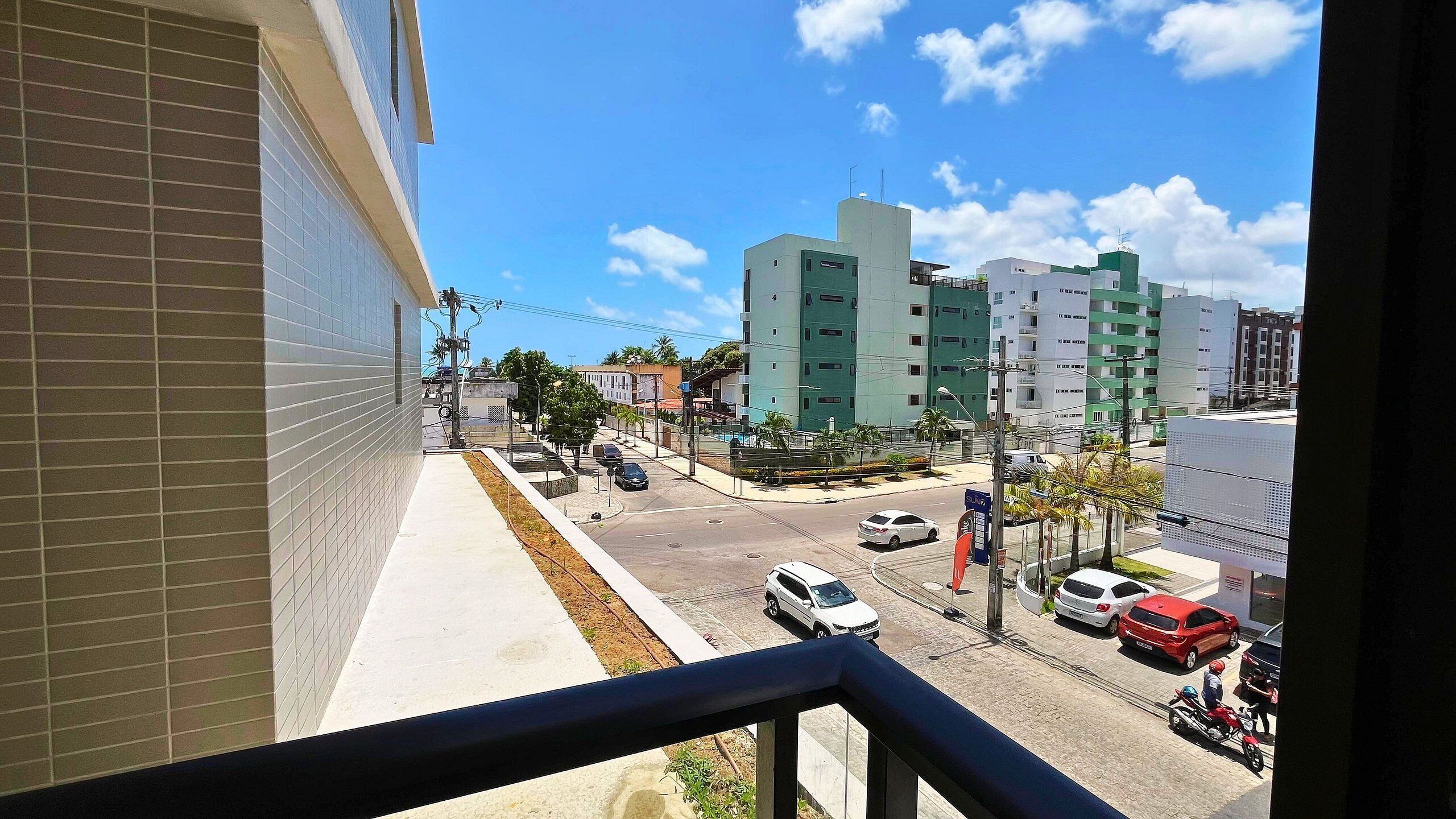 Vista desde un balcón sobre una calle con coches y edificios.