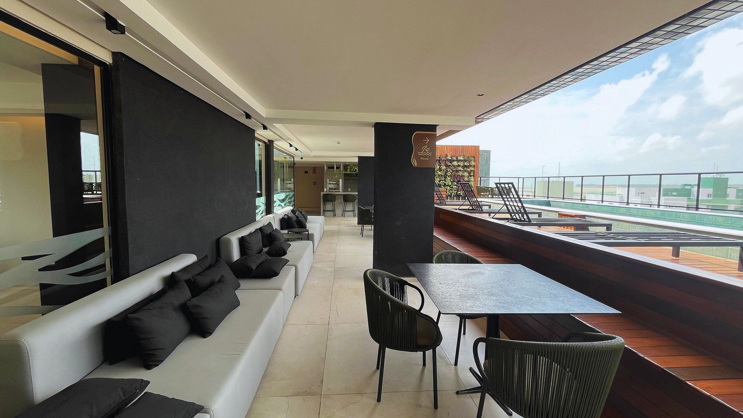A balcony with a sofa, chairs, and a table.