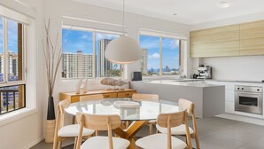 Una cocina moderna con una isla grande, electrodomésticos integrados y vistas a rascacielos.