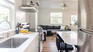 Een moderne keuken met een groot eiland, een inbouwoven en een roestvrijstalen koelkast.