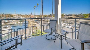 Un balcon donnant sur une marina, avec des chaises et une table.
