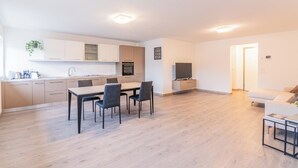 Eine moderne Wohnung mit Küche, Essbereich und Wohnzimmer.