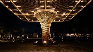 A large, illuminated geometric structure with a central column and a surrounding canopy. - Hotel Mousai - 2 bedroom (Cancún)