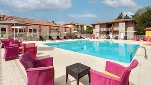 Un área de piscina con sillas de descanso y una piscina.