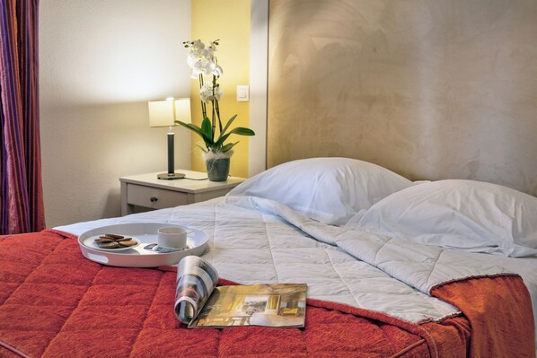 A neatly made bed with white linens, a red throw blanket, a tray with cookies and a cup, and a magazine on the bed. - Les Bords de l'Aveyron (Negrepelisse)