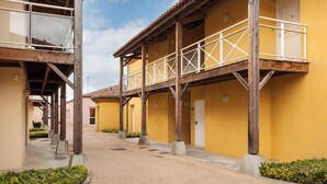 Una hilera de edificios amarillos con balcones de madera y un paseo cubierto.