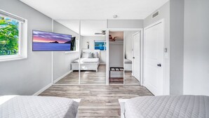 Een moderne slaapkamer met een bed, een televisie en uitzicht op de omgeving.