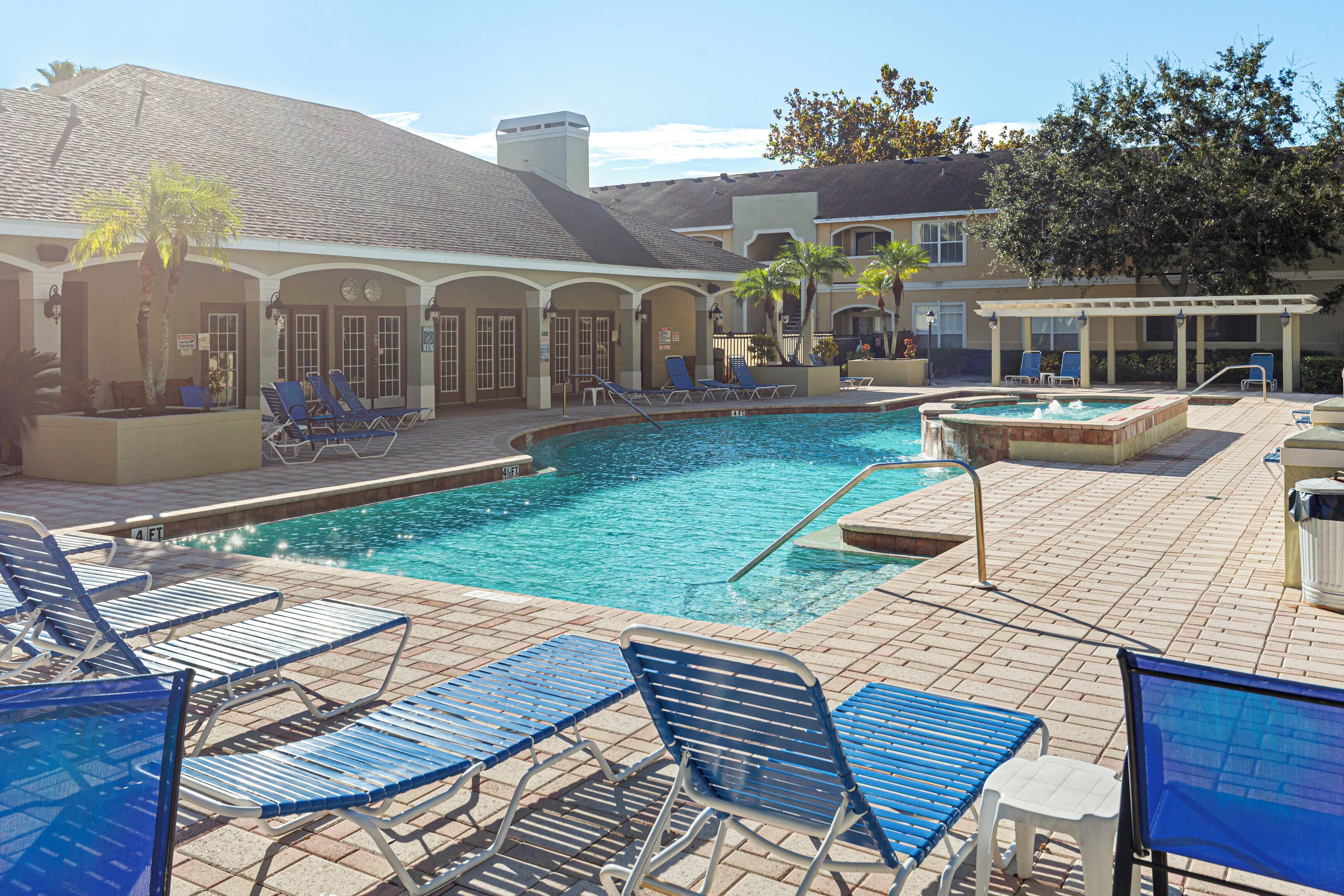 A pool area with lounge chairs and a hot tub.