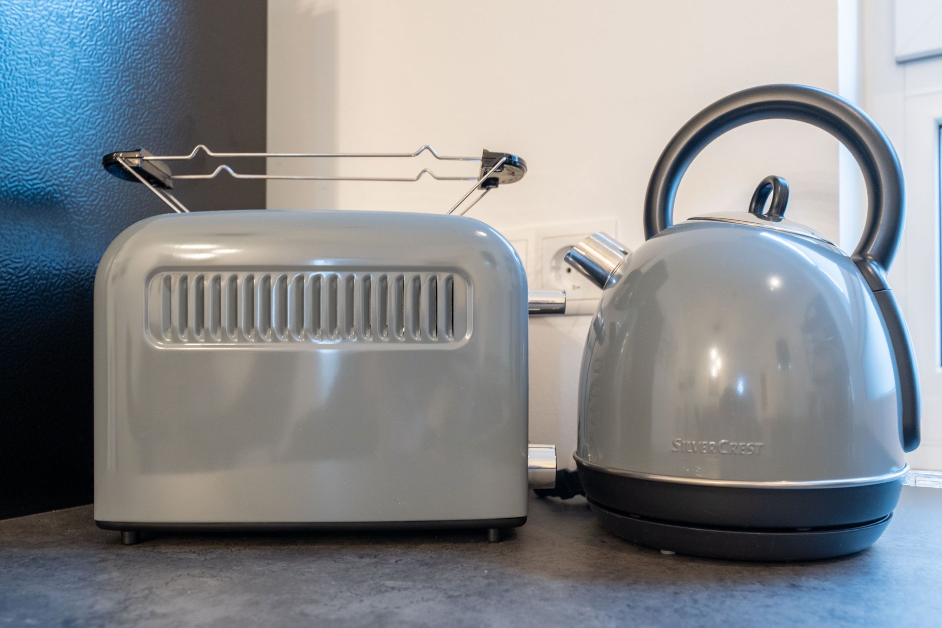 A kitchen with a toaster and a kettle on the counter.
