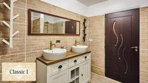 Un baño con dos lavamanos, un espejo grande y una puerta de madera con pomos decorativos.