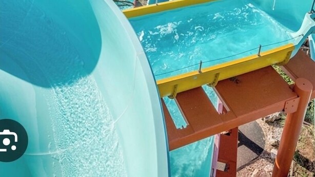 Ein Wasserpark mit großem Pool, Rutschen und Blick auf den Strand.
