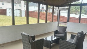 An outdoor patio area with wicker furniture and a ceiling fan. - Vacation Paradise in Jonesboro (Jonesboro)