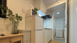 A modern kitchen with white appliances, a wooden countertop, and a plant. - Tasuki Smart Kinshicho II (Tokyo)