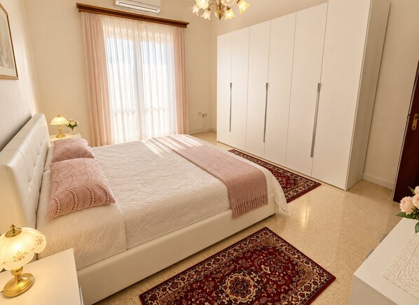 Una camera da letto con un letto, un armadio, un comodino e una lampada.