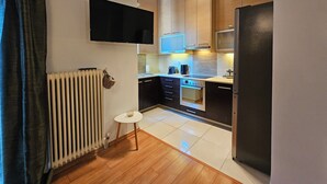 A modern kitchen with a built-in oven, microwave, and a flat-screen TV mounted on the wall.