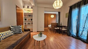 A modern living room with a sofa, a coffee table, and a dining area.