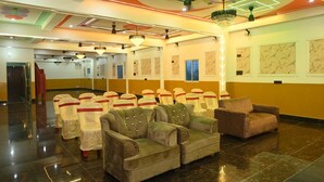 A hotel lobby with a modern design, featuring a seating area with sofas and chairs, a chandelier, and marble wall decorations. - HOTEL NIRVANA INN (Rajgir)