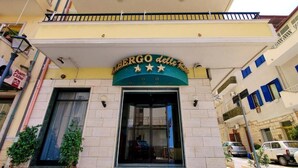 Entrada de hotel com uma placa indicando "L'ERGO delle Rose" e uma varanda acima.