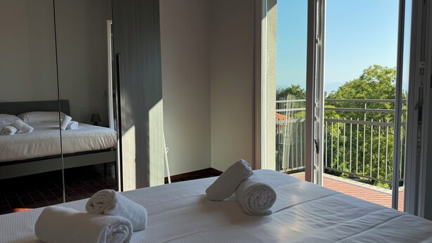 Ein Hotelzimmer mit Bett, Fenster und Balkon.