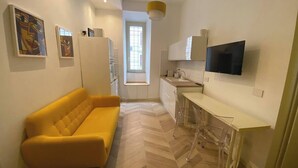 A compact kitchen with a dining area, a sofa, and artwork on the walls. - Alice's apartment 1 (Roma)