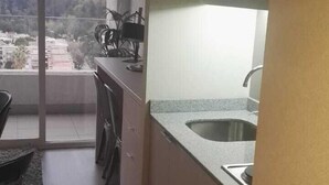 A modern kitchen with a large window, a sink, and a dishwasher. - Departamento Centro de viña del mar (Vina del Mar)