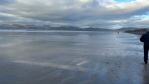 A beach with a person walking towards the water, mountains in the background, and a cloudy sky. - Beautiful 7 BR Home Ring of Kerry - Beach -Golf nearby - Killarney 30 min.drive (Killarney)
