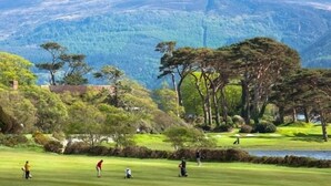 A golf course with players, trees, and a lake. - Beautiful 7 BR Home Ring of Kerry - Beach -Golf nearby - Killarney 30 min.drive (Killarney)