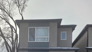 Una casa de dos pisos con un puerta principal, un pequeño porche y el número 226 a la vista.