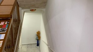 Eine Treppe mit einer weißen Backsteinmauer und einem Holgeländer links.