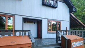 Un edificio con terraza de madera, una escalera y un cartel que dice 'WELCOME'.