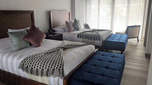 A hotel room with two beds, a bedside table with a phone, a chair, and a large window with sheer curtains. - Hotel Boutique Mitad del Mundo (Pomasqui)