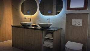 A modern bathroom with two vessel sinks, a wooden vanity, and a toilet. - Hotel Boutique Mitad del Mundo (Pomasqui)