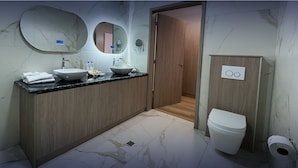 A modern bathroom with a marble floor, two sinks, a toilet, and a mirror. - Hotel Boutique Mitad del Mundo (Pomasqui)