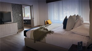 A modern bedroom with a large bed, a TV, and a view of the outdoors. - Hotel Boutique Mitad del Mundo (Pomasqui)