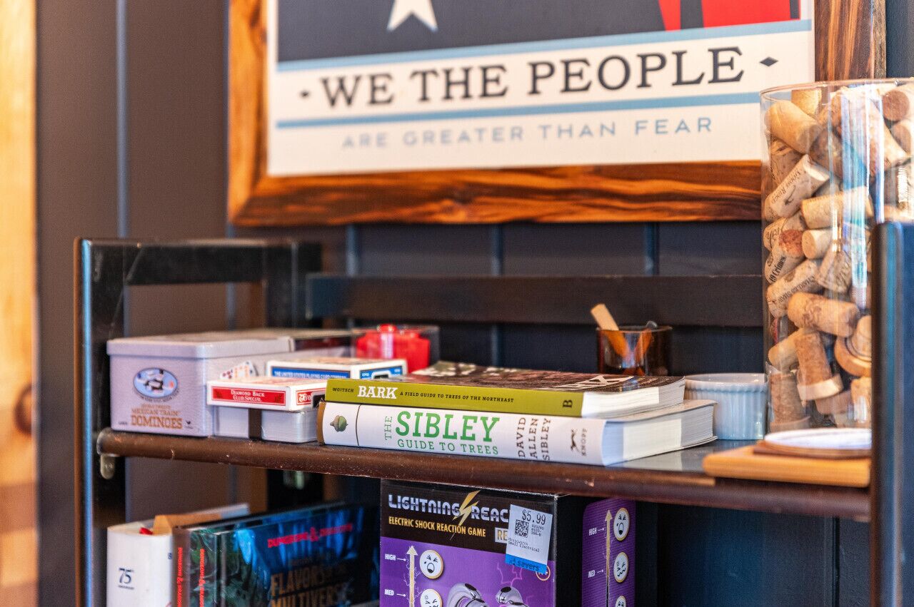 Ein Bücherregal mit Büchern und einem gerahmten Zitat.