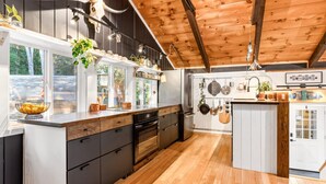 A modern kitchen with wooden flooring, built-in appliances, and a large island. - As Unique as they come! (Intervale)
