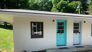 A small, single-story building with two doors, numbered 108 and 109, and a small window. - Historic Blue Ridge Tourist Court - One Bathroom Suite (Boone)