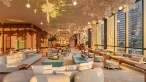 A modern hotel lobby with a central seating area, large windows, and a ceiling with unique light fixtures. - KROMO Bangkok, Curio Collection by Hilton (Bangkok)