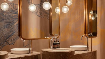 A bathroom with three sinks, each with a round basin and a mirror above.